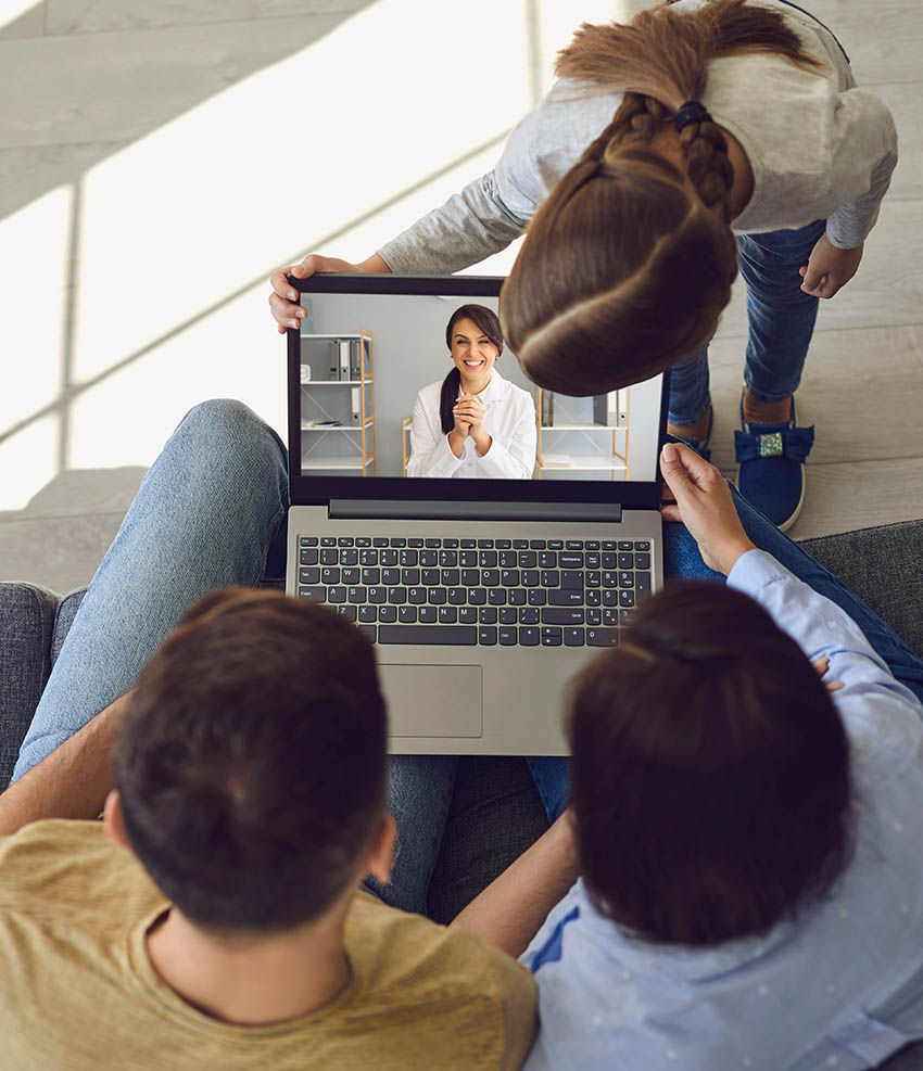 Doctor online. Happy family talks consults with a doctor using a laptop while sitting at home on the couch.